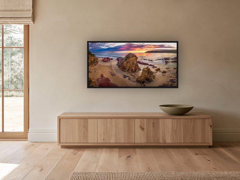 Pambula Beach Sunrise panorama in a black frame above an oak sideboard