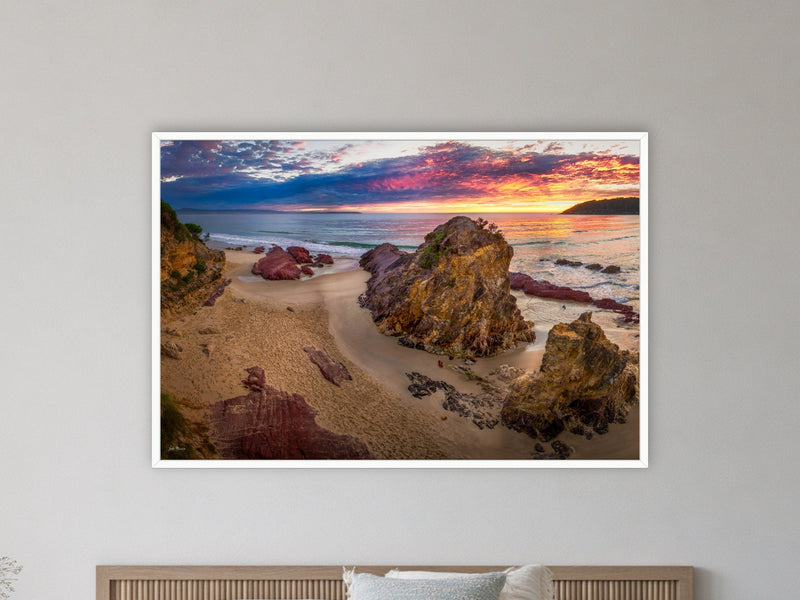 Pambula Beach Sunrise framed print in white above a bed