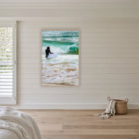 Short Point Surfer in an oak frame without a mat, above the bed in a white coastal bedroom