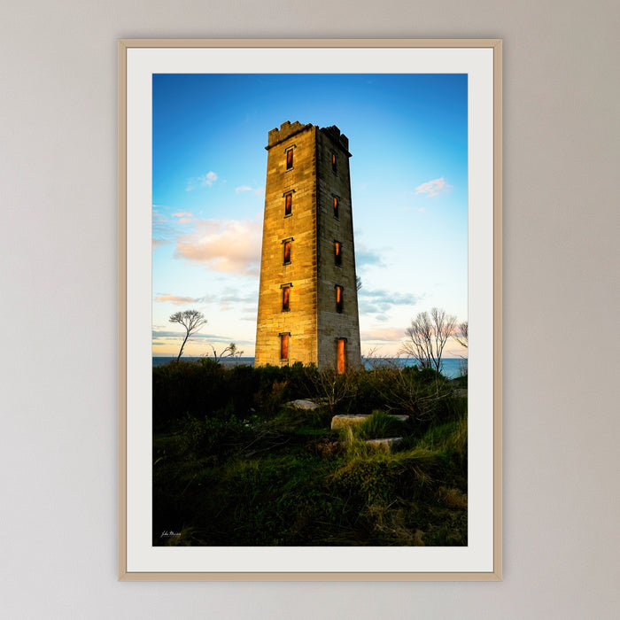 Ben Boyd Tower framed print in oak with a white mat, in a cane-panelled hallway