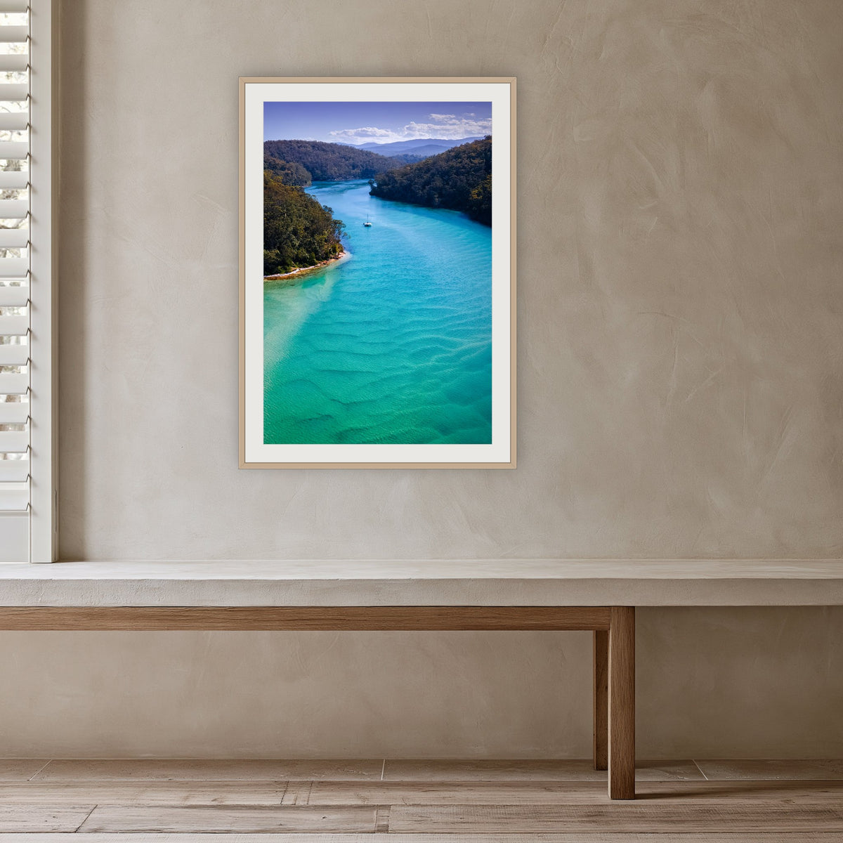 Pambula River Safe Shelter framed print in oak with a white mat, in a plaster-walled hallway