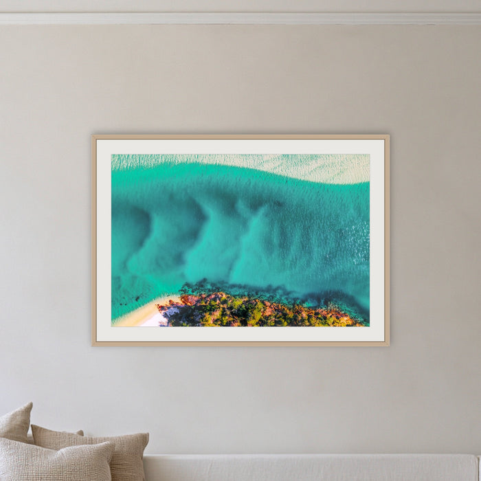 Pambula River Bird's Eye View framed print in oak with a white mat, on a coastal lounge room wall