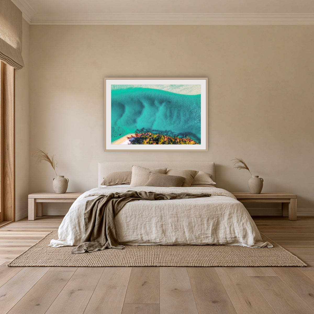 Pambula River Bird's Eye View framed print in oak with a white mat, above an oatmeal linen bed in a bedroom