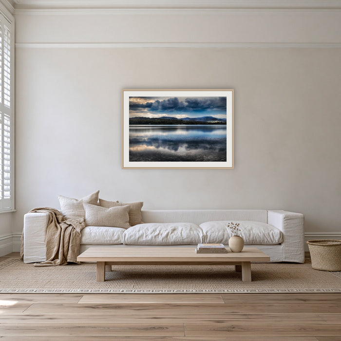 Storm Clouds over Top Lake framed print in oak with a white mat, on a coastal lounge room wall