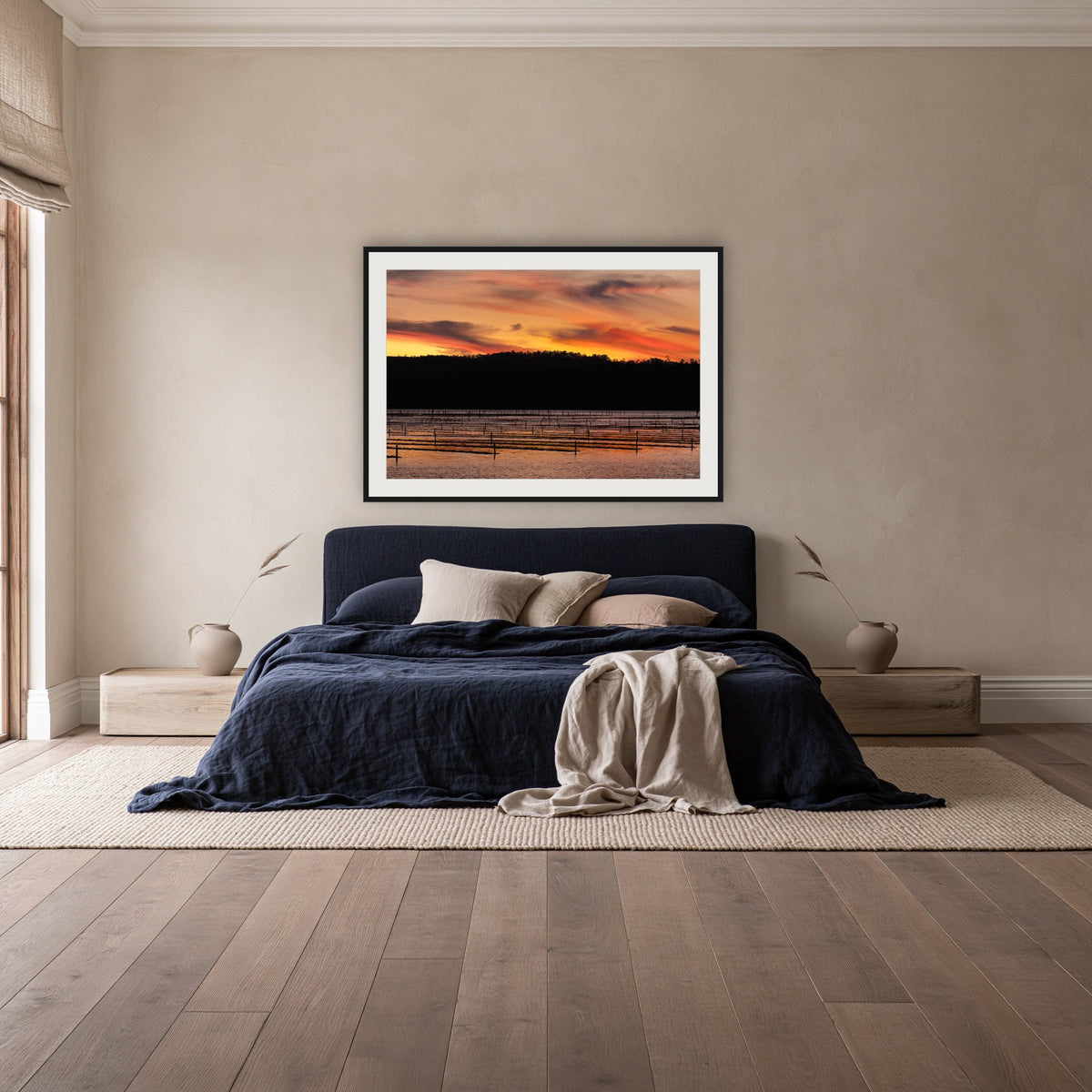 Top Lake Oyster Leases at Sunset framed print in black with a white mat, above a navy linen bed in a bedroom