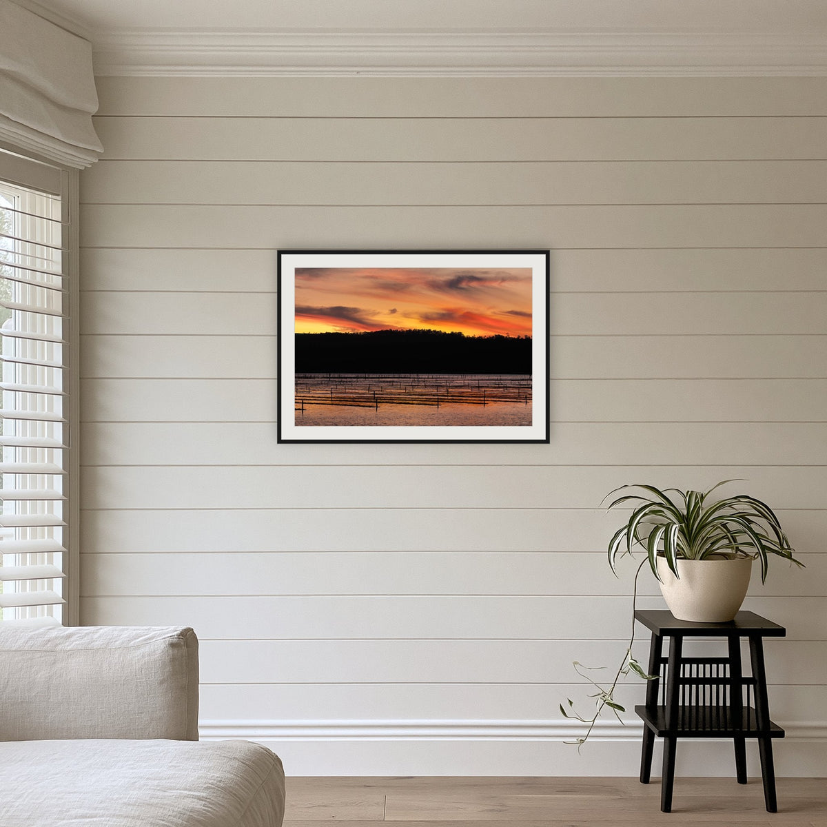 Top Lake Oyster Leases at Sunset framed print in black with a white mat, above a sofa