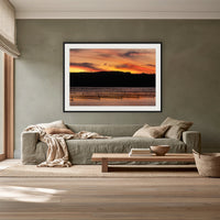 Top Lake Oyster Leases at Sunset framed print in black with a white mat, above a sage linen sofa in a lounge room