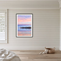 Pastel Pink Paradise framed print in black with a white mat, in a coastal bedroom