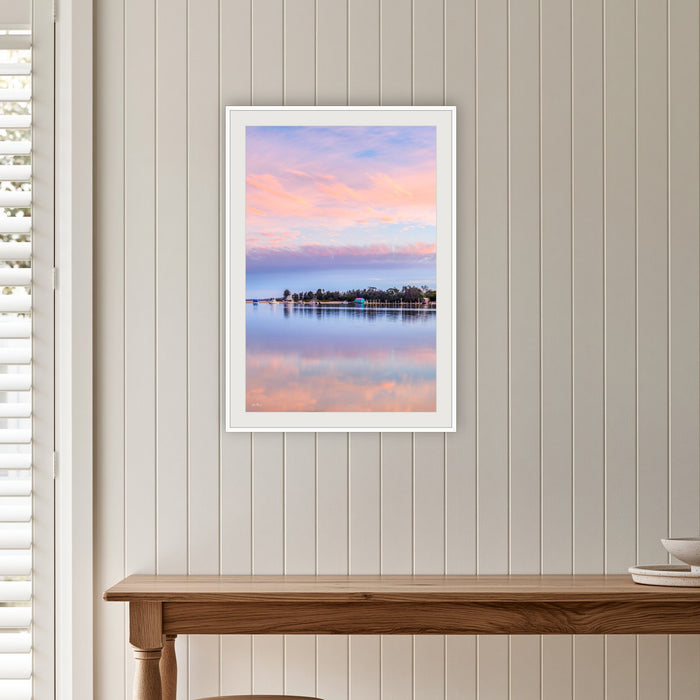 Pastel Pink Paradise framed print in white with a mat, on a panelled hallway wall