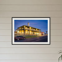 Tathra Hotel framed print in black with a white mat, above a sofa