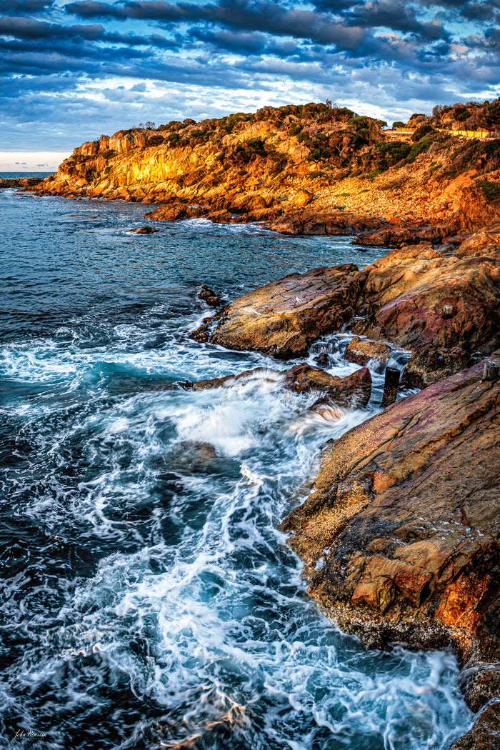 Waves surging over the ancient rock shelves beside Tathra Wharf — fine art print