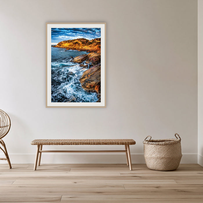 Tathra Rocks framed print in oak with a white mat, in a cane-panelled hallway