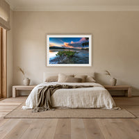 Merimbula through a Mangrove Tree framed print in oak with a white mat, above an oatmeal linen bed in a bedroom