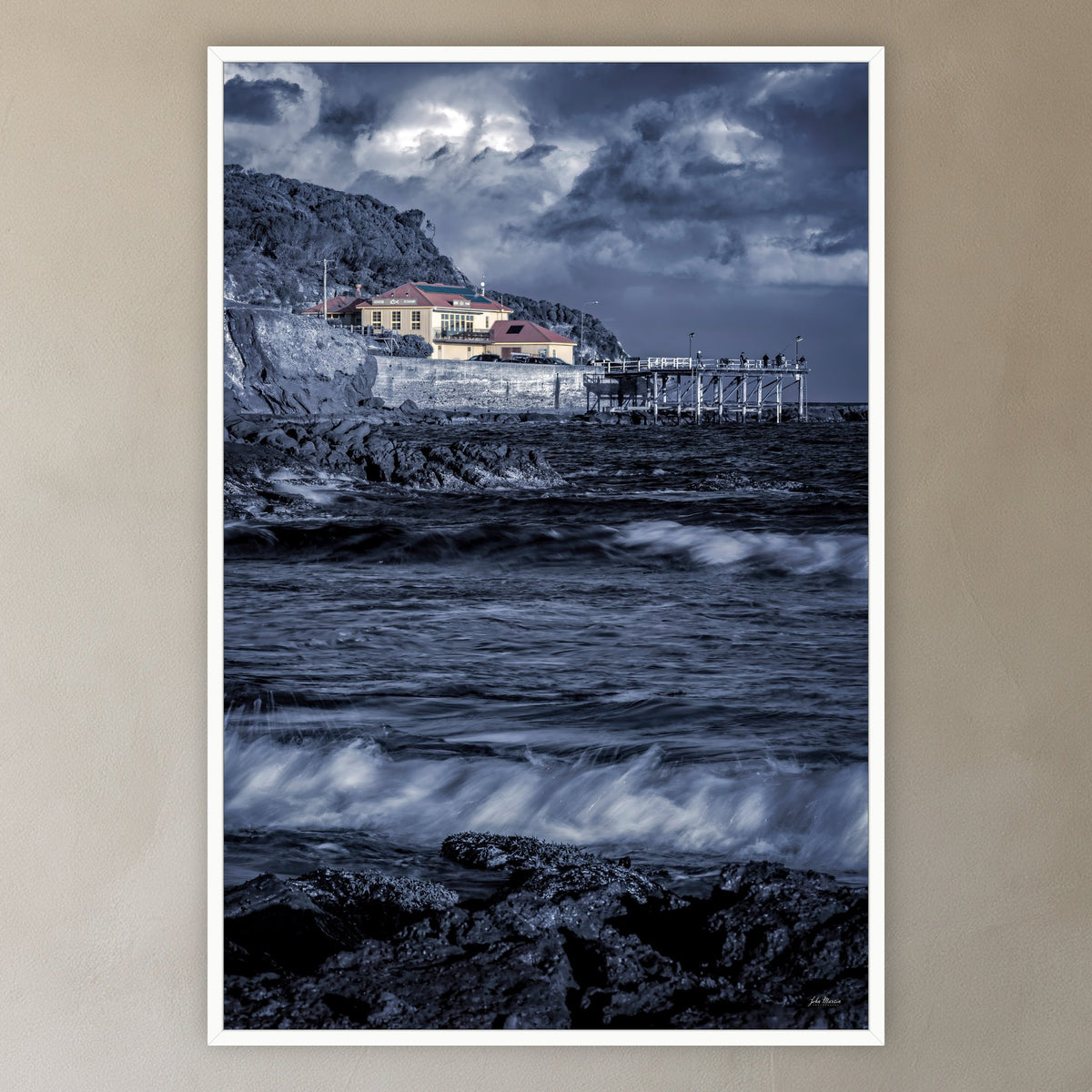 Merimbula Wharf B&W with Colour in a white frame without a mat, in a plaster-walled hallway