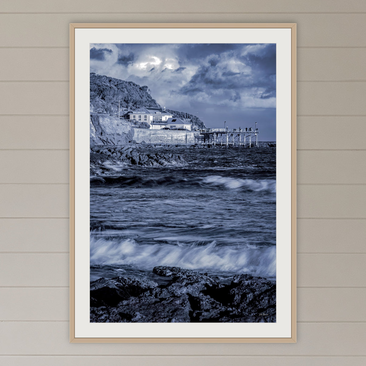 Merimbula Wharf framed print in oak with a white mat, on a coastal lounge room wall