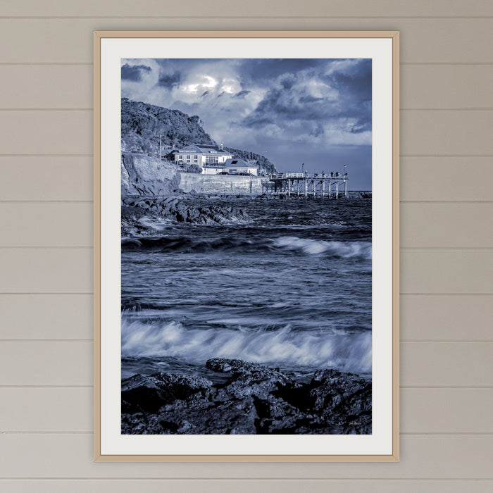 Merimbula Wharf framed print in oak with a white mat, on a coastal lounge room wall