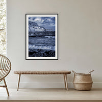 Merimbula Wharf framed print in black with a white mat, in a cane-panelled hallway