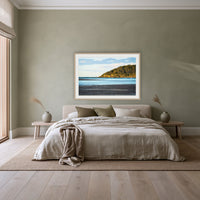 Pambula River Sea Entrance framed print in oak with a white mat, above a linen bed against a sage wall in a bedroom