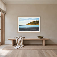Pambula River Sea Entrance framed print in oak with a white mat, above an oak bench in a hallway
