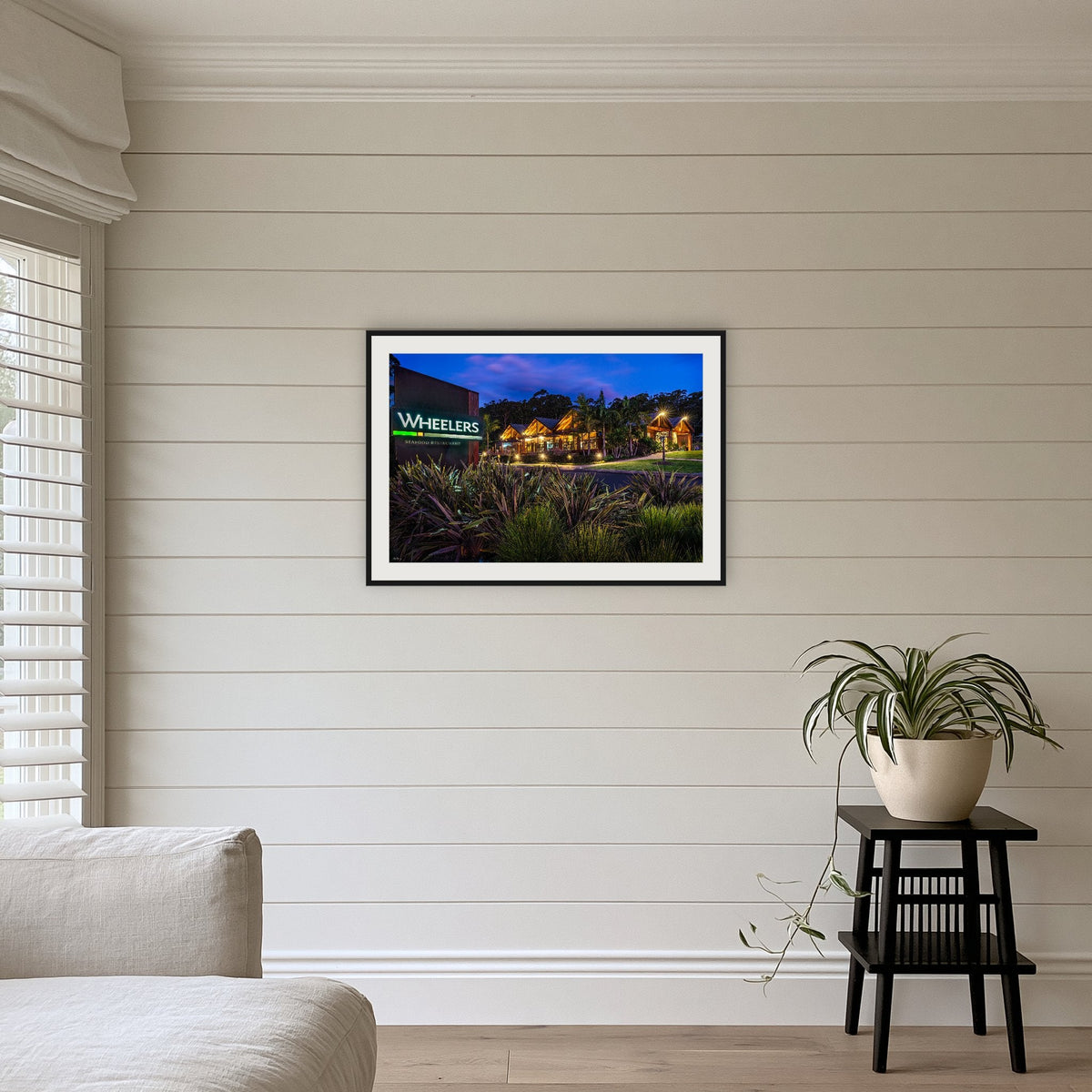 Wheelers Restaurant framed print in black with a white mat, above a sofa