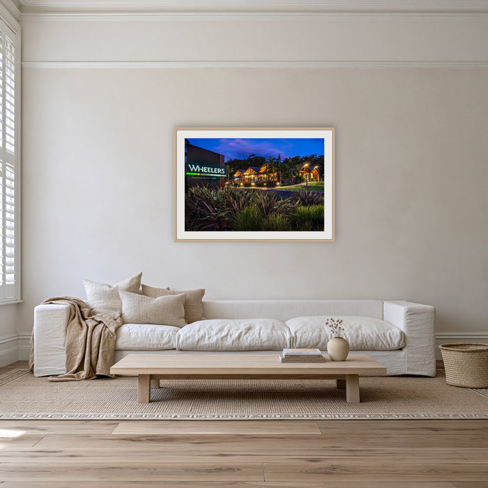 Wheelers Restaurant framed print in oak with a white mat, on a coastal lounge room wall