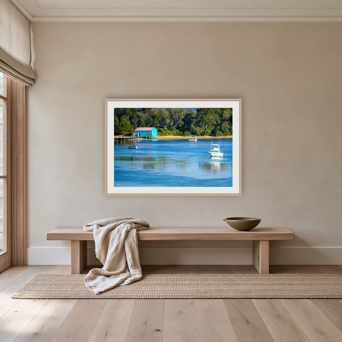 Mitchies Jetty framed print in oak with a white mat, above an oak bench in a hallway