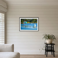 Mitchies Jetty framed print in black with a white mat, above a sofa