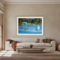 Mitchies Jetty framed print in oak with a white mat, above an oatmeal linen sofa in a lounge room
