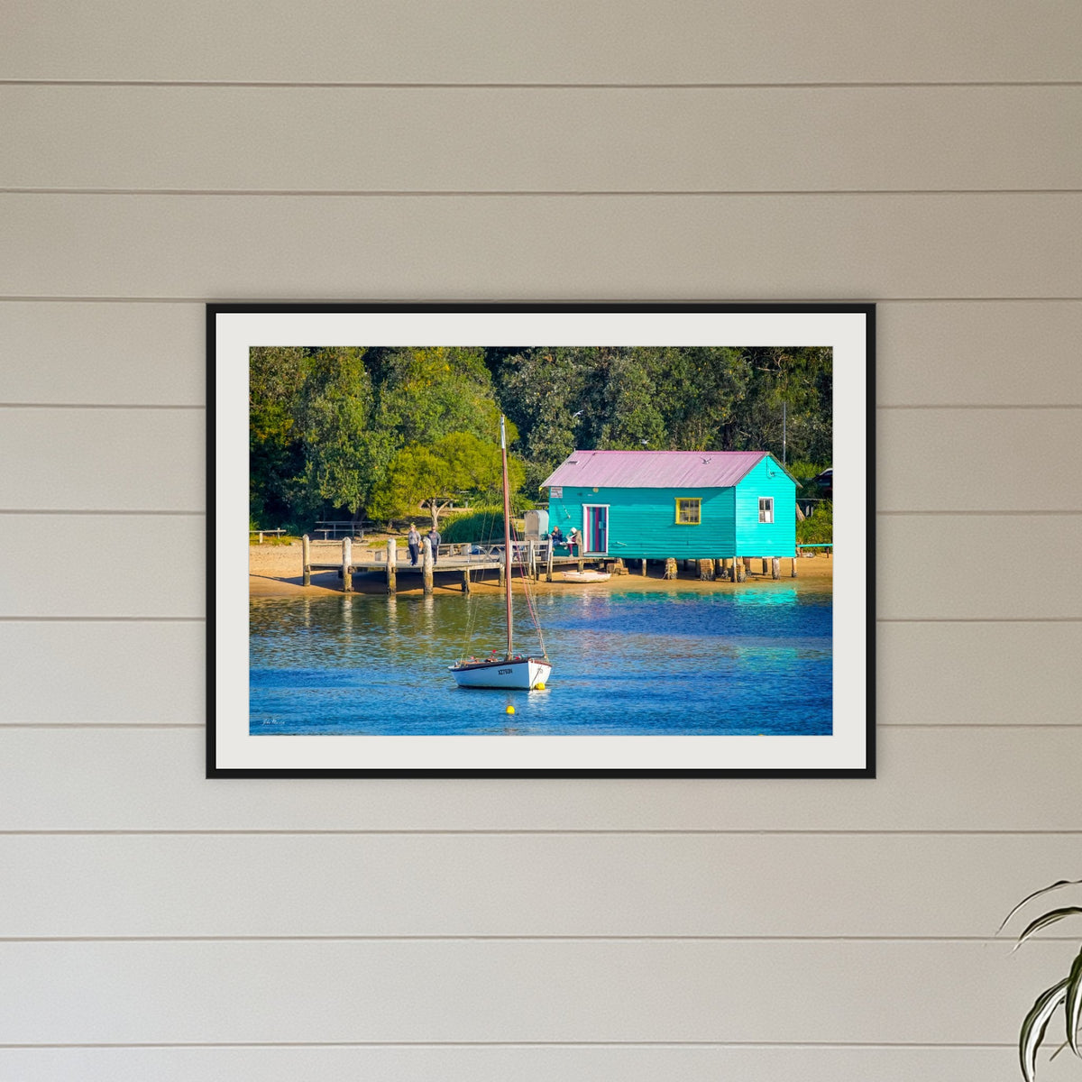Mitchies Jetty Close Up framed print in black with a white mat, above a sofa