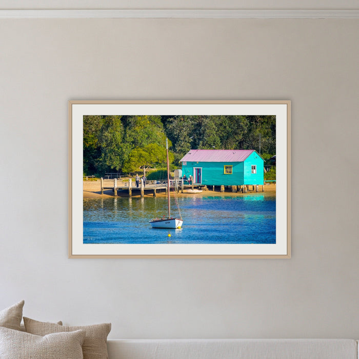 Mitchies Jetty Close Up framed print in oak with a white mat, on a coastal lounge room wall
