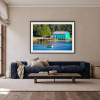 Mitchies Jetty Close Up framed print in black with a white mat, above a navy linen sofa in a lounge room