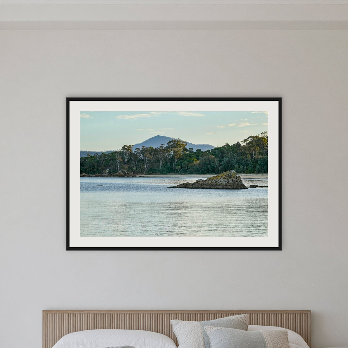 Twofold Bay framed print in black with a white mat, in a bedroom