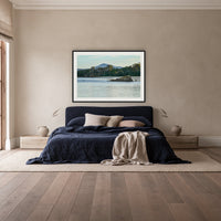 Twofold Bay framed print in black with a white mat, above a navy linen bed in a bedroom
