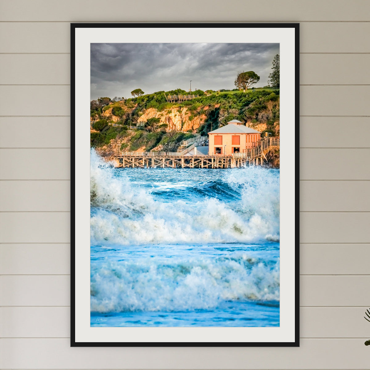 Tathra Wharf and Waves framed print in black with a white mat, in a coastal bedroom