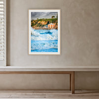 Tathra Wharf and Waves framed print in oak with a white mat, in a plaster-walled hallway