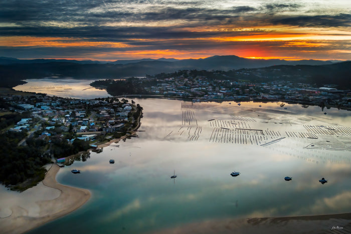Aerial view over Merimbula Lake at dusk, the township along the shore, oyster leases in rows and the sky mirrored in still water — fine art print