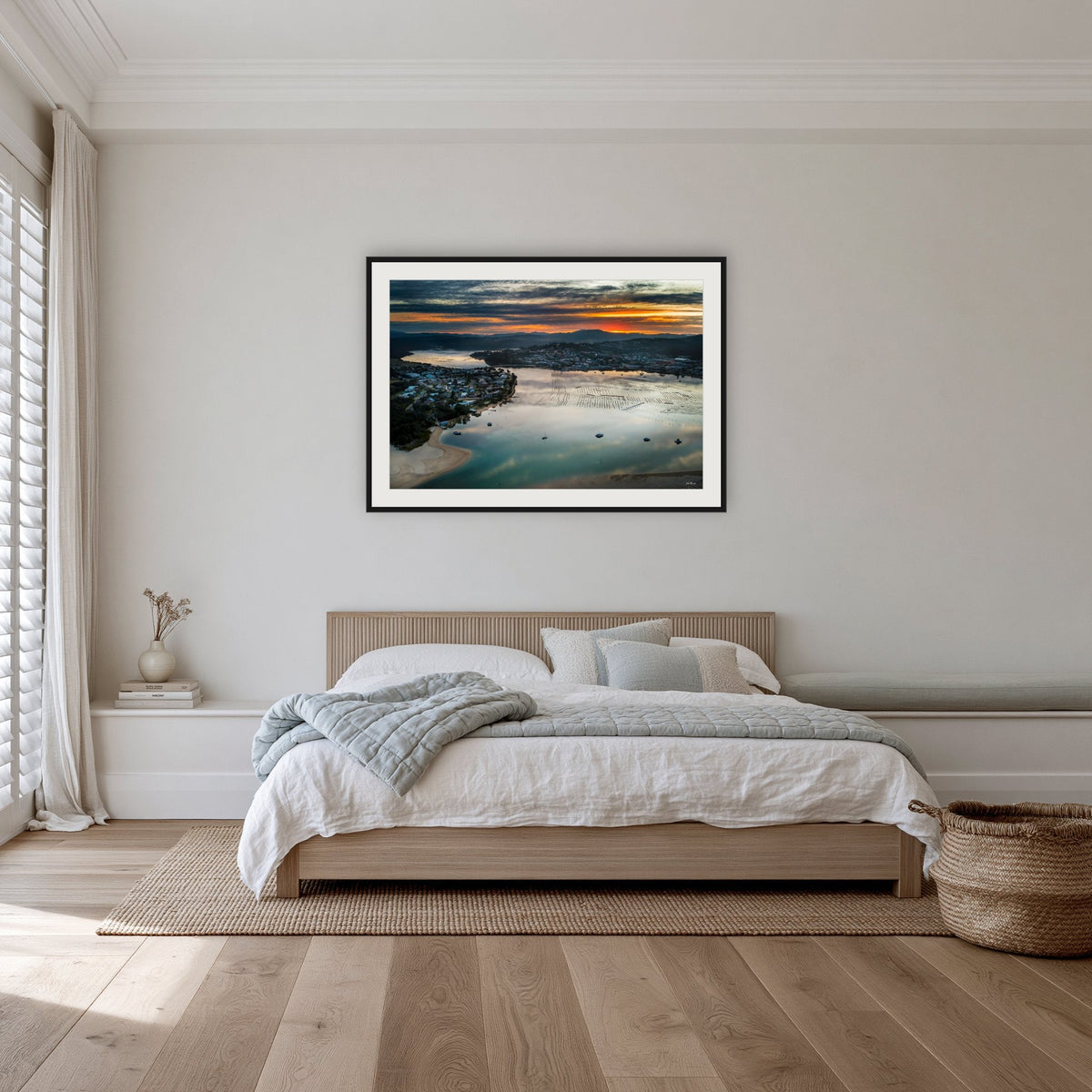 Merimbula Eagle Eye Sunset framed print in black with a white mat, in a bedroom