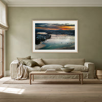 Merimbula Eagle Eye Sunset framed print in oak with a white mat, above a linen sofa against a sage wall in a lounge room