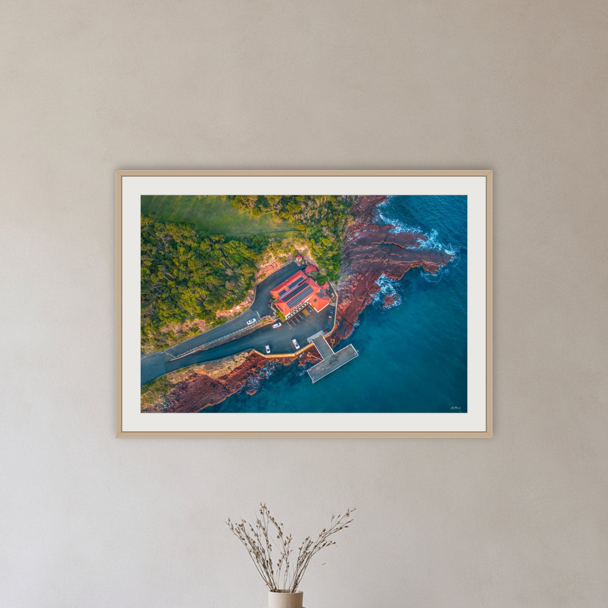 Merimbula Wharf framed print in oak with a white mat, in a hallway