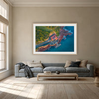 Merimbula Wharf framed print in oak with a white mat, above a dusty blue linen sofa in a lounge room