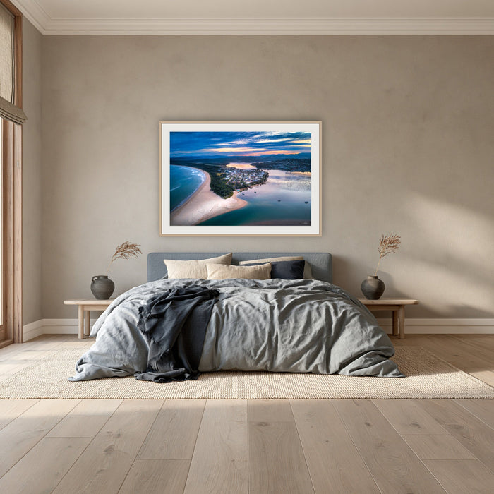 Fishpen on Dusk framed print in oak with a white mat, above a dusty blue linen bed in a bedroom