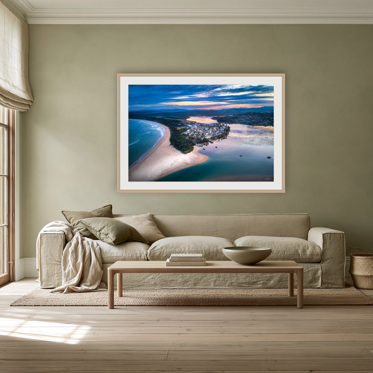 Fishpen on Dusk framed print in oak with a white mat, above a linen sofa against a sage wall in a lounge room