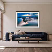 Fishpen on Dusk framed print in black with a white mat, above a navy linen sofa in a lounge room
