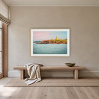Ben Boyd Tower Seascape framed print in oak with a white mat, above an oak bench in a hallway