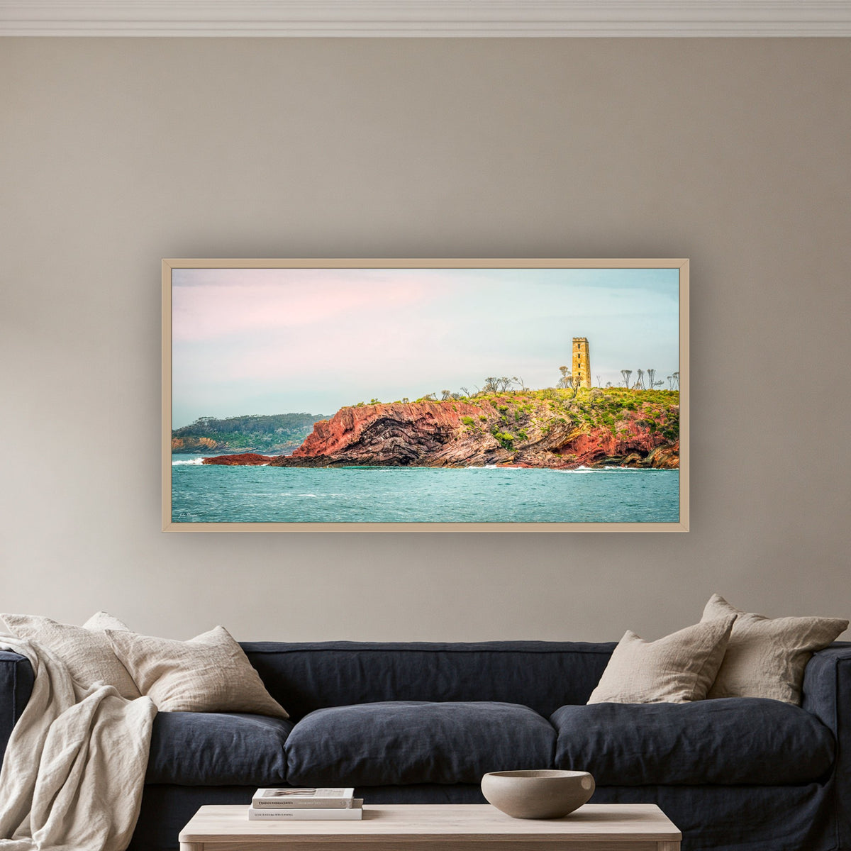 Ben Boyd Tower from the Sea wide panorama in an oak frame above a navy linen sofa — wall art, Eden NSW
