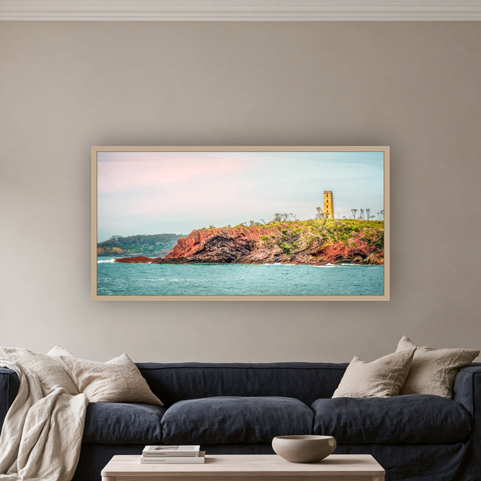 Ben Boyd Tower from the Sea wide panorama in an oak frame above a navy linen sofa — wall art, Eden NSW