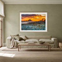 Mimosa Rocks Sunrise framed print in oak with a white mat, above a linen sofa against a sage wall in a lounge room