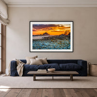Mimosa Rocks Sunrise framed print in black with a white mat, above a navy linen sofa in a lounge room