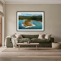 Mimosa Rocks framed print in black with a white mat, above an olive linen sofa in a lounge room