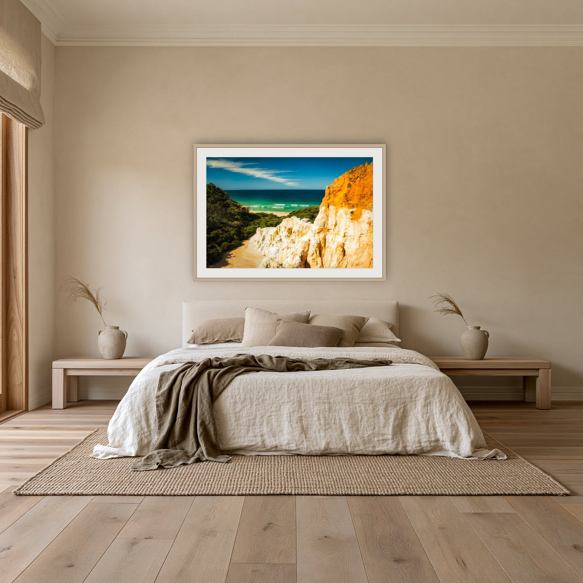 The Pinnacles framed print in oak with a white mat, above an oatmeal linen bed in a bedroom